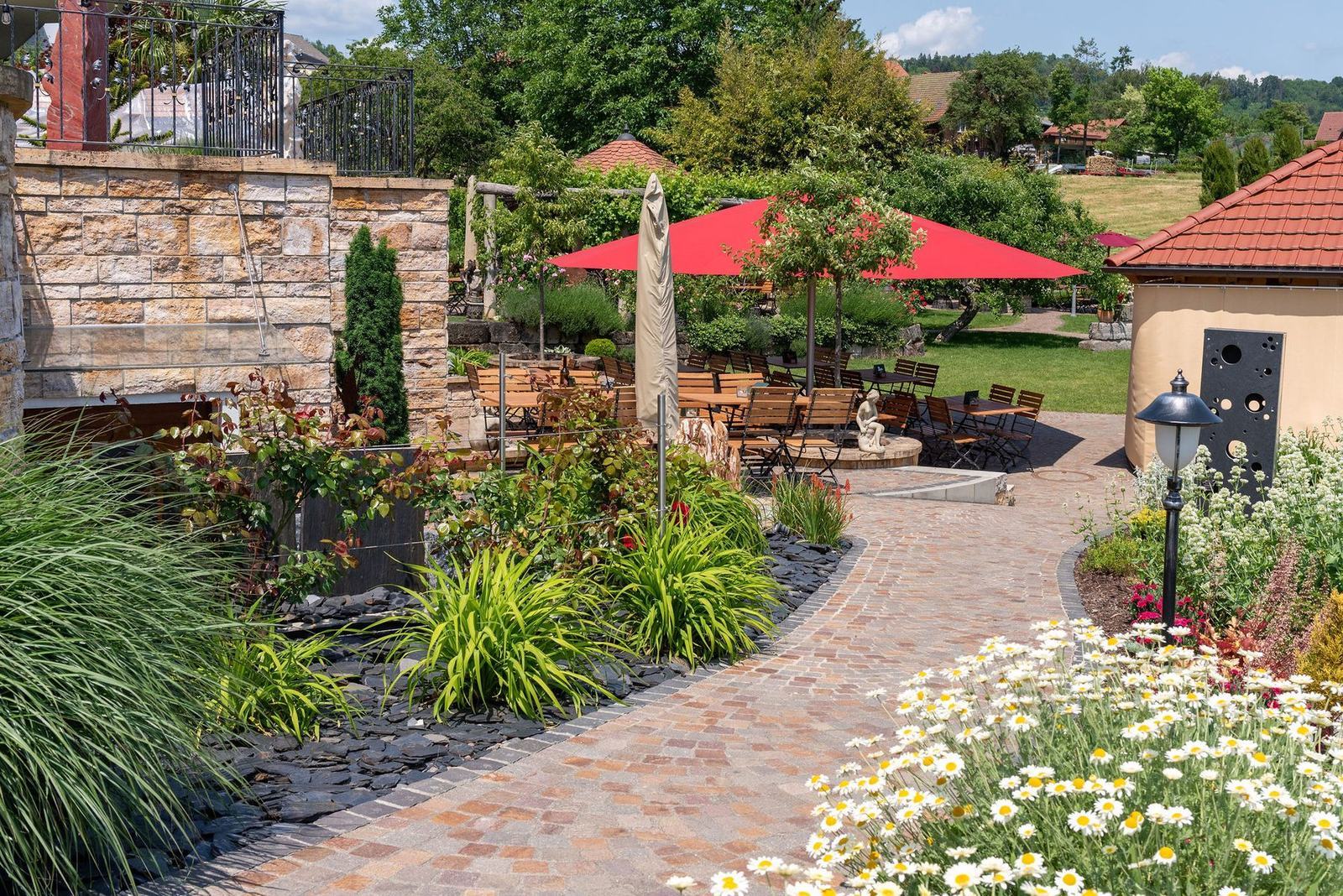 Terrasse mit Natursteinmauer und Sitzplätzen