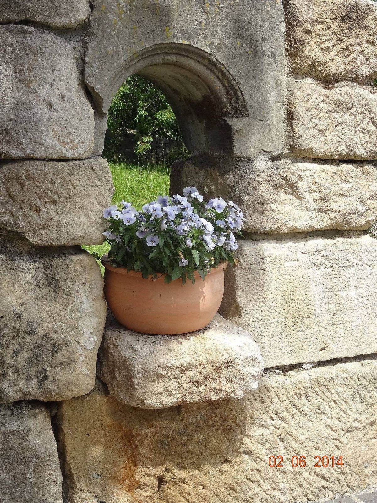 Nische mit Blumen in einer Natursteinmauer