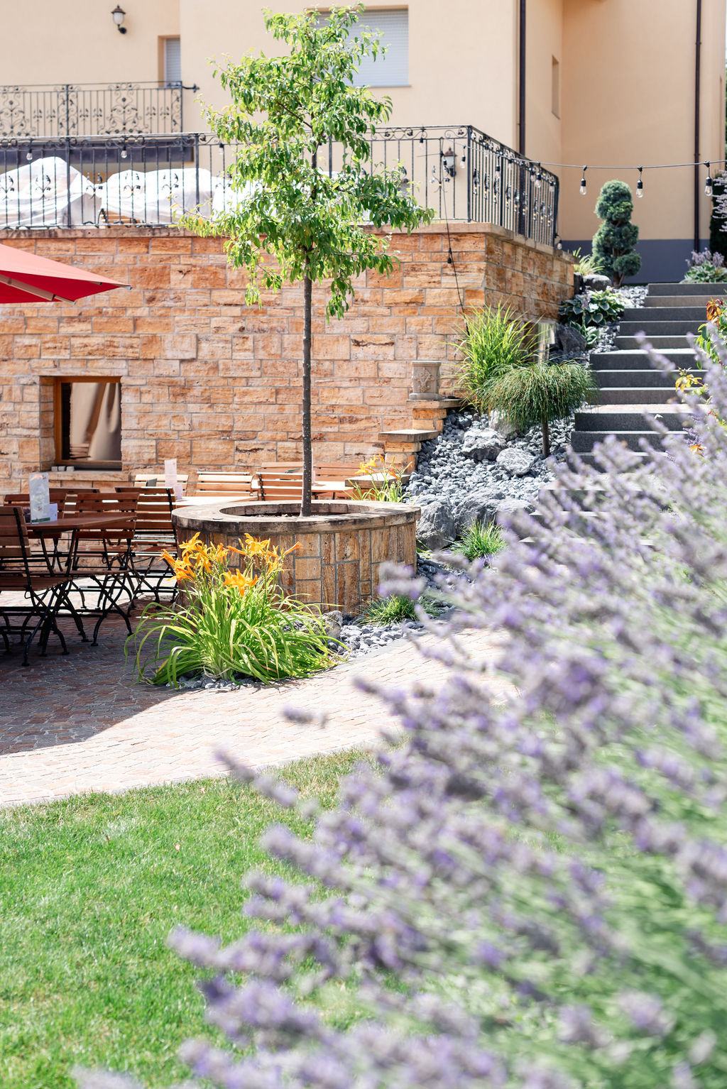 Café-Terrasse mit rotem Sonnenschirm und Lavendel