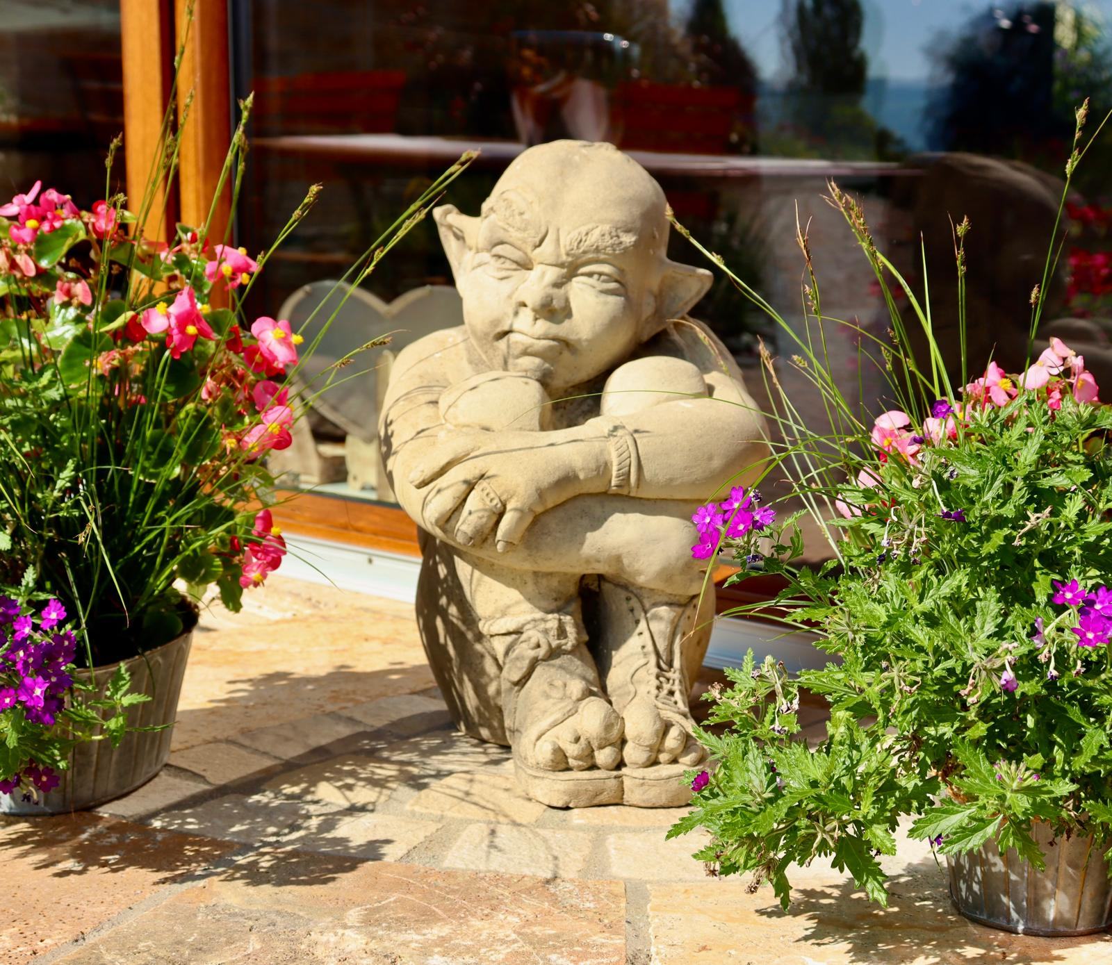 Steinfigur eines Kobolds im Beet