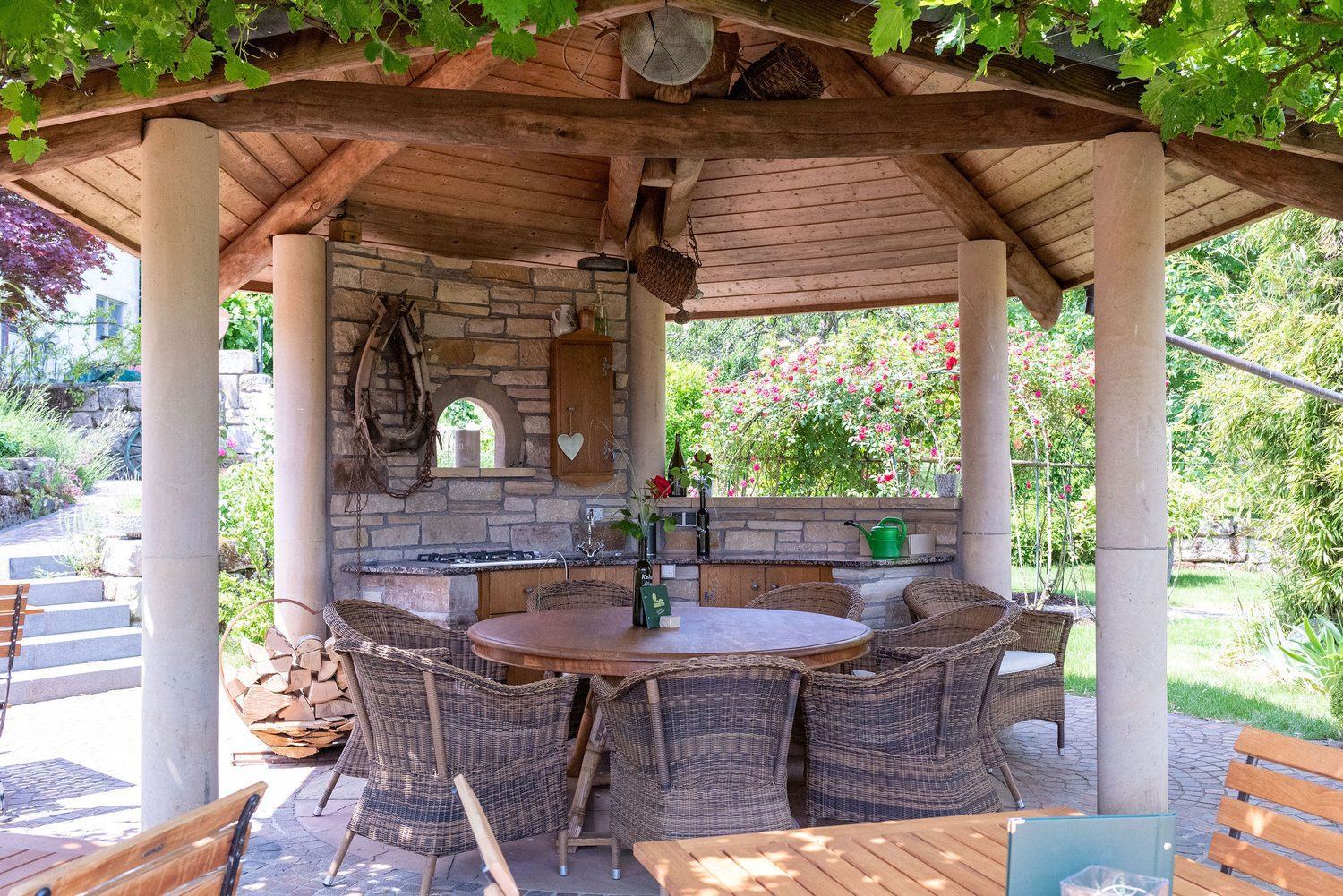Pavillon im Sommergarten – gedeckter Tisch unter Rosen