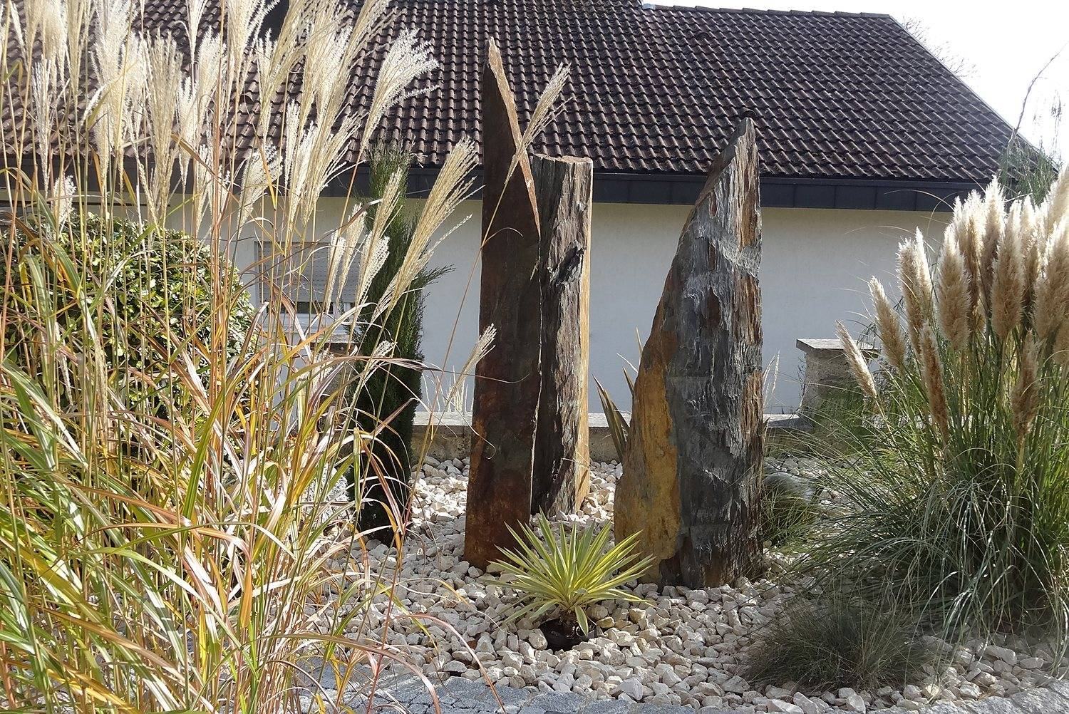 Stelen mit Gräsern im Steingarten